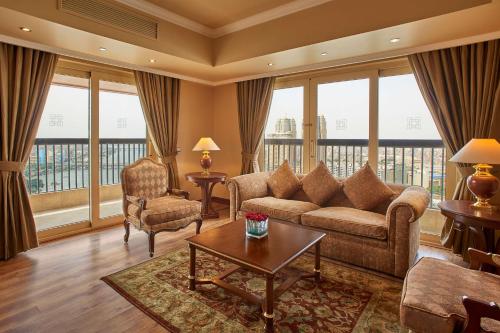 a living room with a couch and chairs and windows at Hilton Cairo Zamalek Residences in Cairo