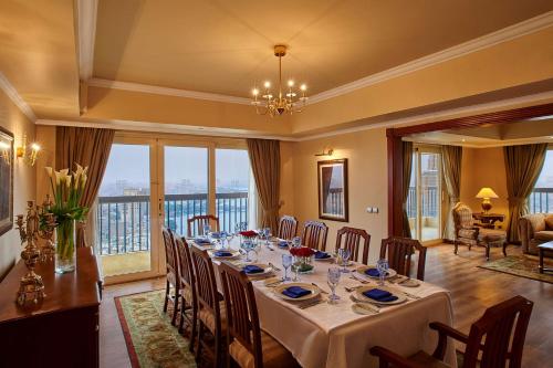 a dining room with a long table and a large window at Hilton Cairo Zamalek Residences in Cairo