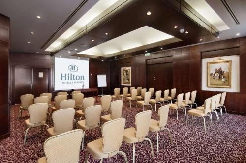 a conference room with a row of chairs and a screen at Hilton Cairo Zamalek Residences in Cairo