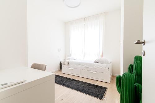 a white bedroom with a bed and a window at Bella Lì - by MyHomeInComo in Menaggio