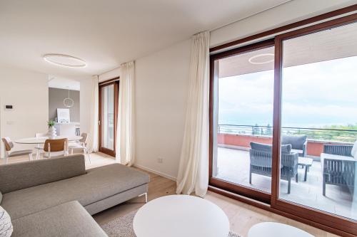 a living room with a couch and a large window at Bella Lì - by MyHomeInComo in Menaggio