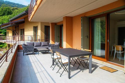 a patio with a table and chairs on a balcony at Bella Lì - by MyHomeInComo in Menaggio