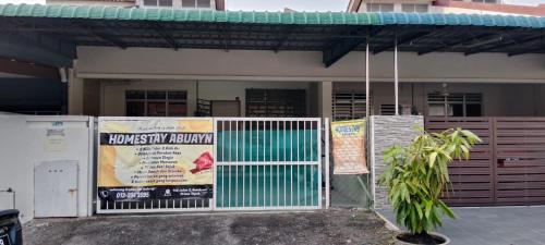 a house with a gate and a sign in front of it at Homestay Abu Ayn Islam in Tapah
