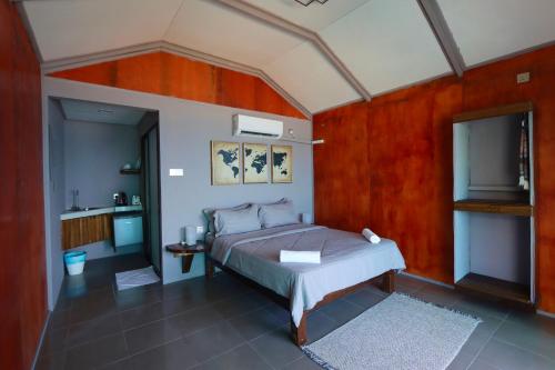 a bedroom with a bed and a tv in it at Pondok Beach Shack in Tioman Island