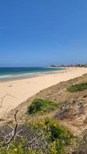 una spiaggia con persone che nuotano nell'oceano di Maison Sidi bouzid a Sidi Bouzid