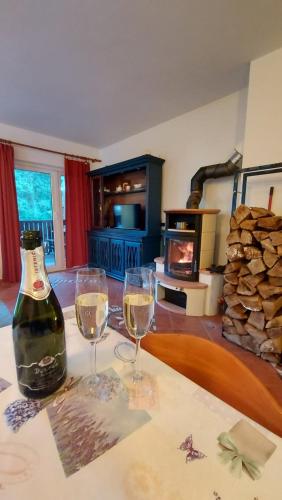 two glasses of wine sitting on a table in a living room at Rogla Apartma Kekec in Vitanje