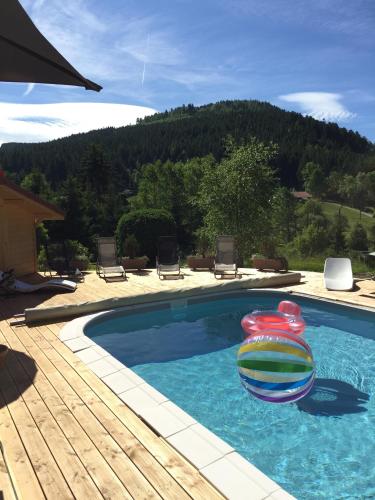 a swimming pool with a float in the water at Maison La Devinière - sauna et spa compris accessibles toute l'année in Xonrupt-Longemer