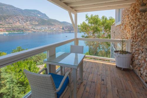 a table and chairs on a balcony with a view of the water at Likya Gardens Hotel in Kas