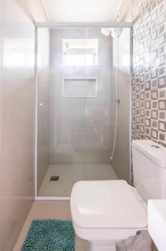アングラ・ドス・レイスにあるLoft 102 - Espaço Praia Aptosのトイレとガラスのシャワー付きのバスルーム