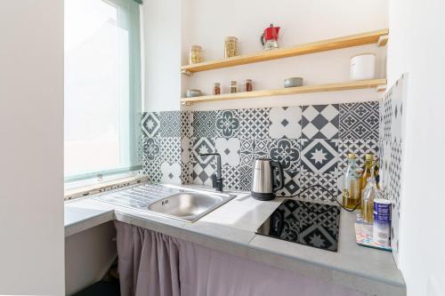 eine Küche mit einem Waschbecken und einem Fenster in der Unterkunft Casa Ancora TownHouse in Catania