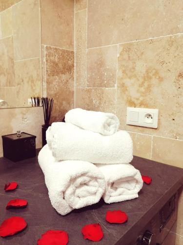 a bathroom with white towels and red hearts on a counter at L'Atelier de rêves in Metz