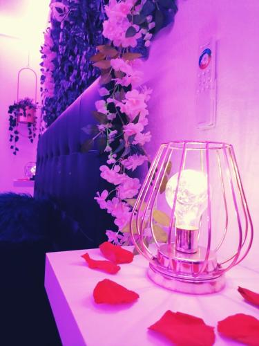 a table with a vase with pink flowers on it at L'Atelier de rêves in Metz