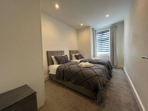 1 dormitorio con 2 camas y ventana en Star London Bell Lane 3-Bed Oasis with Garden en Hendon