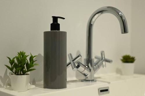 a soap dispenser sitting on top of a bathroom sink at Modern house in Birmingham in Birmingham