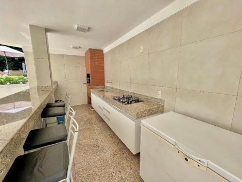 a kitchen with a sink and a counter with chairs at Condomínio Vivence in Fortaleza