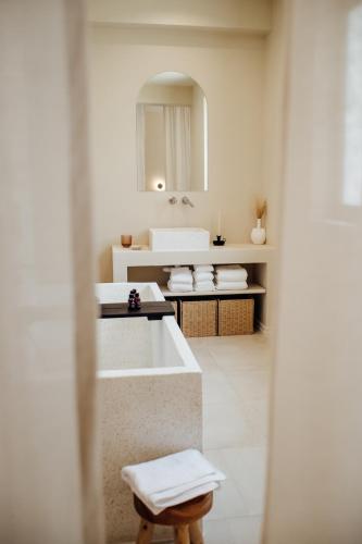 a bathroom with a tub and a sink and a mirror at Thymises Boutique Hotel in Kakopetria