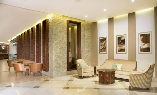 a lobby with a couch and chairs and tables at Hilton Garden Inn Dubai Al Mina - Jumeirah in Dubai
