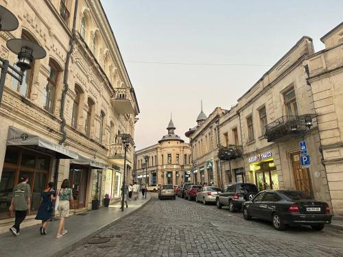 a city street with buildings and cars parked on the street at Guest House Memo at the center of kutaisi in Kutaisi