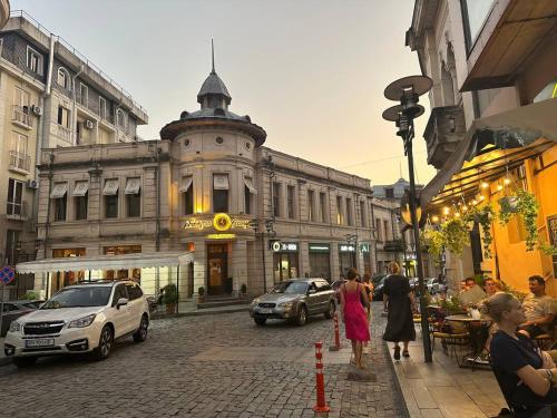 a group of people walking down a city street at Guest House Memo at the center of kutaisi in Kutaisi