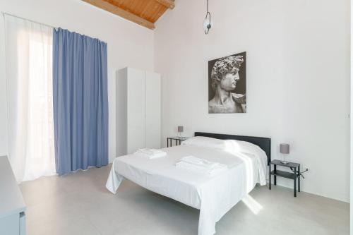 ein weißes Zimmer mit einem Bett und einem Tisch in der Unterkunft Casa Ancora TownHouse in Catania