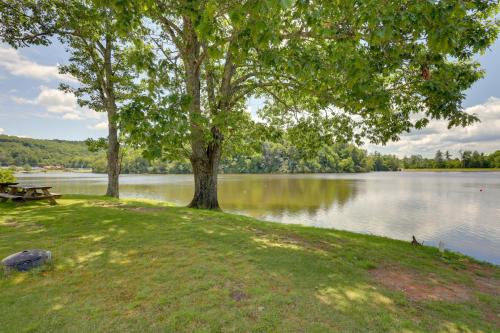 a tree and a picnic table next to a lake at In Golf Community with Pool Access Newland Cabin in Newland