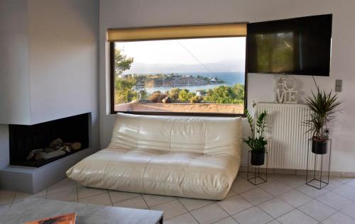 a living room with a white couch and a large window at Seaview Resort in Chalkida