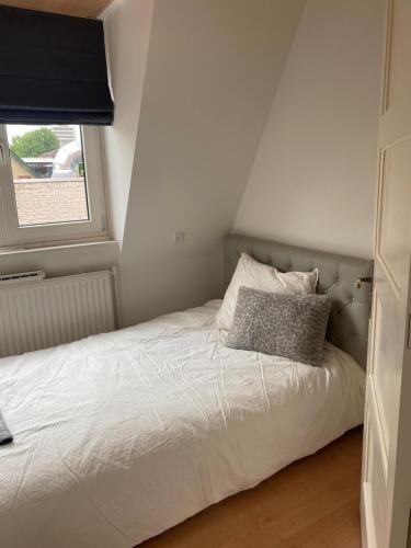 a bed in a small room with a window at Free Fly Loft Drachten in Drachten