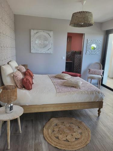 une chambre avec un grand lit et une table dans l'établissement Aux jolies pierres, à Laouque