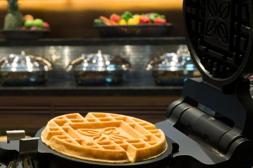 a waffle sitting on top of a machine with at Hilton Garden Inn Dubai Deira in Dubai