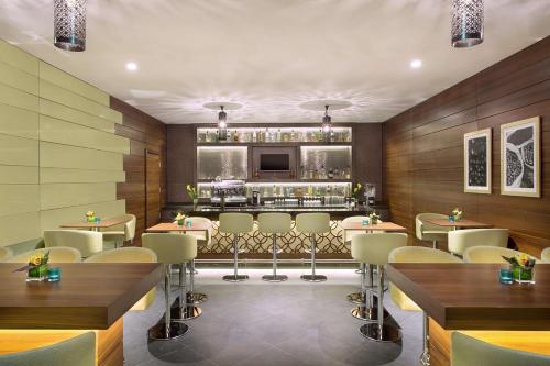a restaurant with tables and chairs and a bar at Hilton Garden Inn Dubai Deira in Dubai