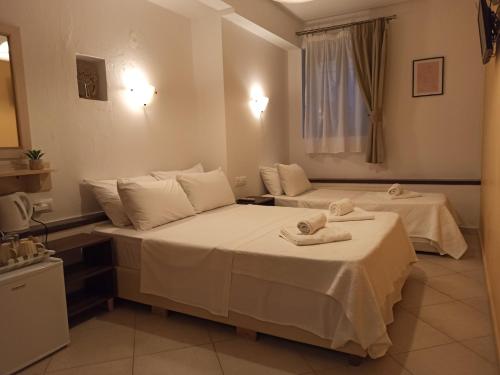 a hotel room with two beds with towels on them at To Agioklima in Ioannina