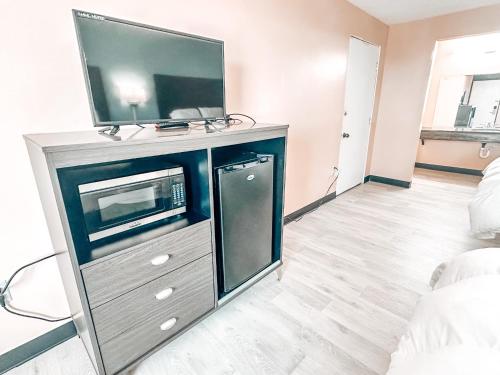 a living room with a flat screen tv on a entertainment center at Laker Inn in Jamestown