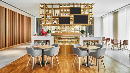 a restaurant with tables and chairs in a room at Hilton Garden Inn Dubai, Mall Avenue in Dubai
