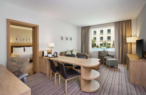 a hotel room with a table and a bed at Hilton Garden Inn Dubai, Mall Avenue in Dubai