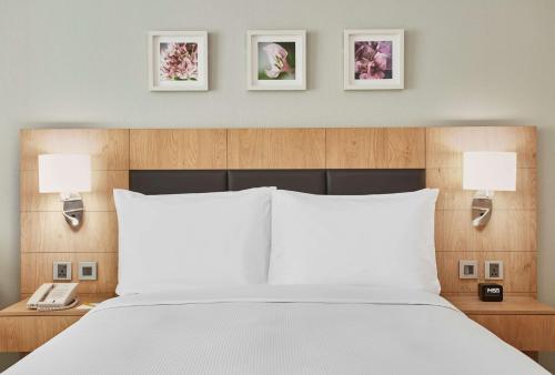 a bedroom with a bed with two lamps and a phone at Hilton Garden Inn Dubai, Mall Avenue in Dubai