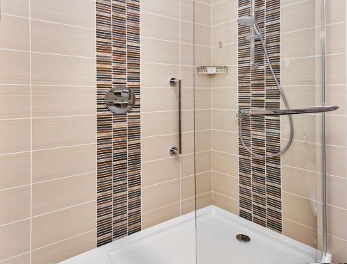 a shower with a glass door in a bathroom at Hilton Garden Inn Dubai, Mall Avenue in Dubai