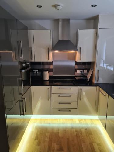 una cucina con armadietti bianchi e piano cottura di Remarkable 1-Bed Apartment in Dartford a Dartford