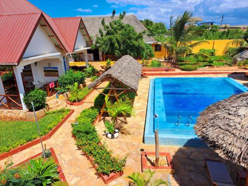 南威的住宿－Mimi na wewe villa，享有带游泳池的房屋的空中景致