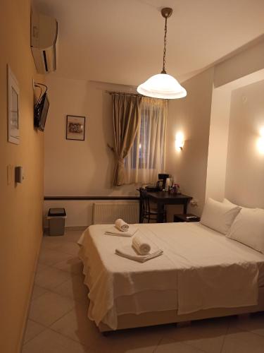 a bedroom with a white bed and a lamp at To Agioklima in Ioannina