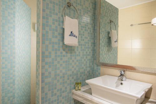 a blue tiled bathroom with a sink and a mirror at Aeolos Beach Resort in Malia