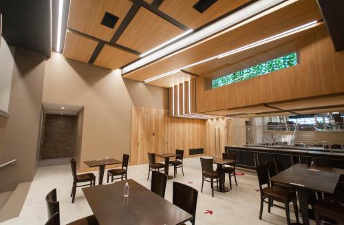 a restaurant with wooden tables and chairs and a bar at Hotel Spa Republica in Mar del Plata