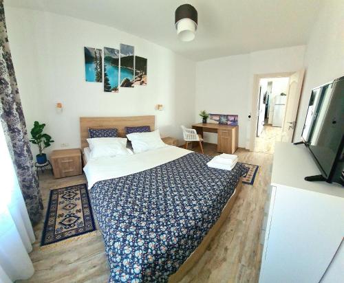 ザルネシュティにあるApartament Eminescuのベッドと机とテレビのある寝室
