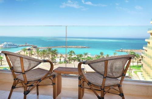 two chairs sitting on a balcony with a view of the ocean at Hilton Hurghada Plaza Hotel in Hurghada