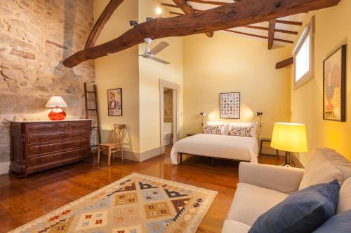 a living room with a bed and a couch at Casa Grande - Minho's Guest in Braga