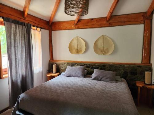 a bedroom with a bed and two mirrors on the wall at Cabaña de montaña (jacuzzi exterior) in San Alfonso