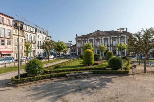 a park with a bench in front of a building at Casa Grande - Minho's Guest in Braga