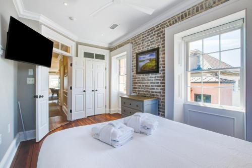a bedroom with a white bed and a window at Rainbow Row Pied-A-Terre in Charleston