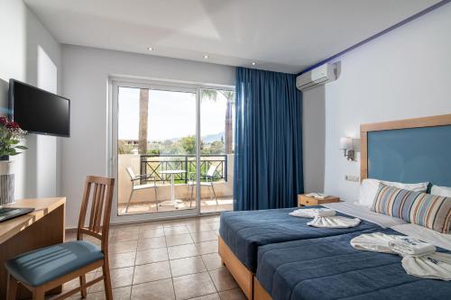 a hotel room with a bed and a balcony at Aeolos Beach Resort in Malia