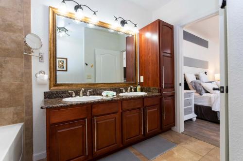 a bathroom with two sinks and a large mirror at Great 2bd condo, Near disney! in Davenport
