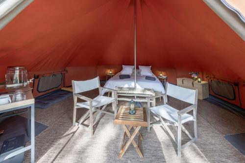 a room with a table and chairs in a tent at Les Toiles du Cassis 